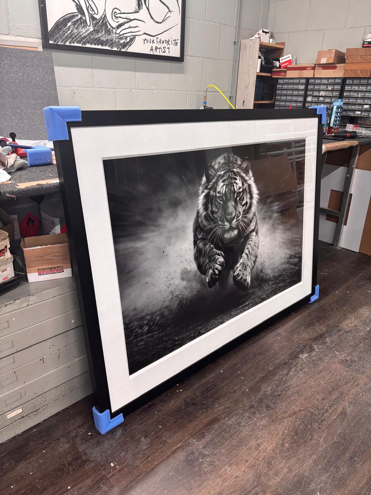 Finished black frame and white archival mount surrounding The Unstoppable
